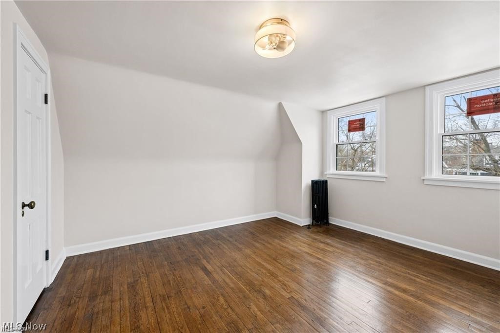 3145 Huntington Road Shaker Heights, OH 44120 - Photo 25 of 28 Wood-finish flooring with white baseboards, twin windows, a ceiling-mounted light fixture, and a built-in radiator