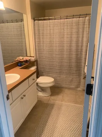 a bathroom with a granite countertop toilet and a sink