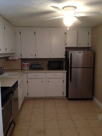 9 Broadway, Unit 217 Saugus, MA 01906 - Photo 11 of 18 a kitchen with a refrigerator a stove a microwave and cabinets