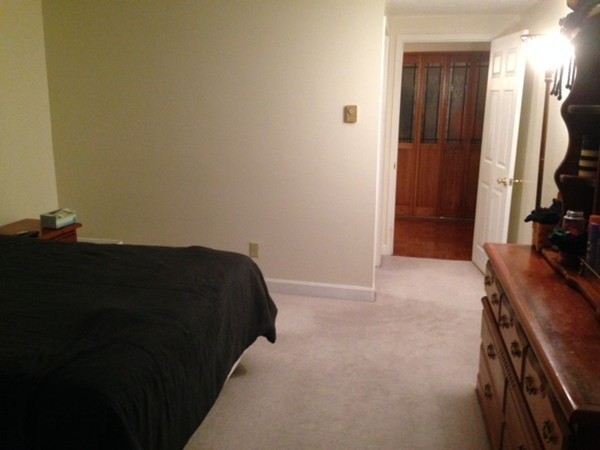 9 Broadway, Unit 217 Saugus, MA 01906 - Photo 15 of 18 a bedroom with a bed and a flat tv screen on a dresser