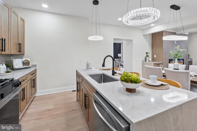 a kitchen with a stove a sink and a chandelier
