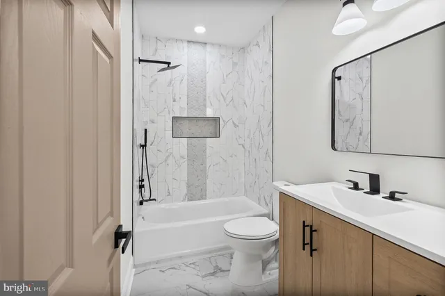 a bathroom with a bathtub shower sink vanity and toilet