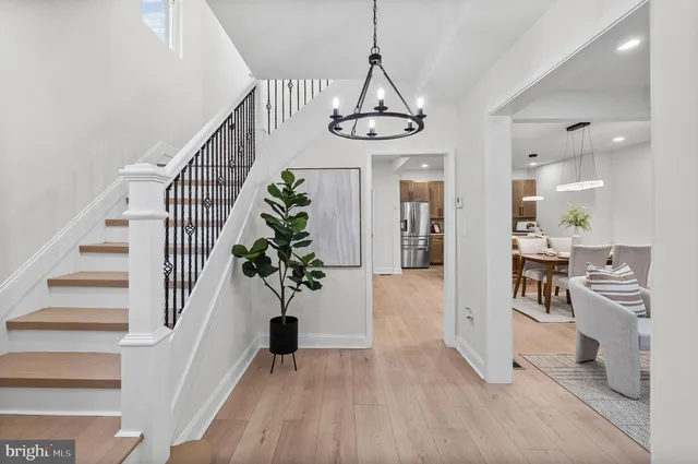 a view of a hallway with wooden floor windows and a chandelier