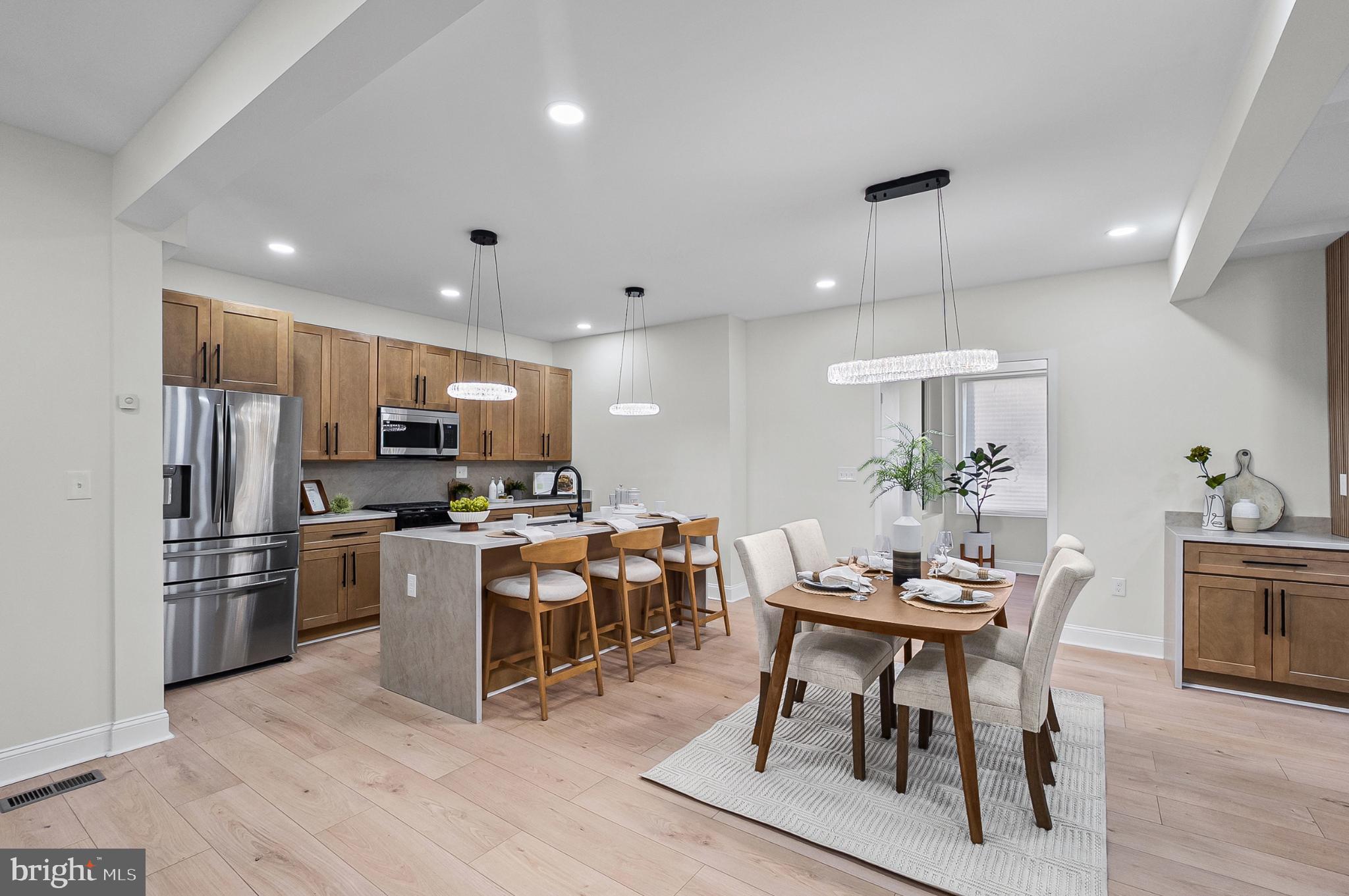 3703 Egerton Road Baltimore, MD 21215 - Photo 9 of 32 a kitchen with stainless steel appliances kitchen island granite countertop a table and chairs in it