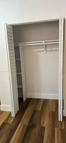 a view of walk in closet with wooden floor