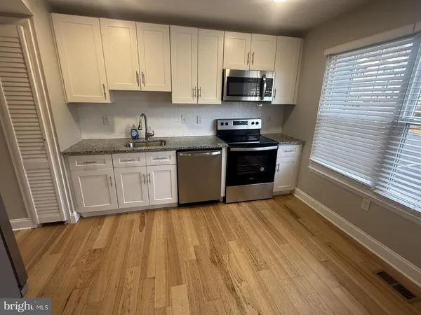 a kitchen with wooden floors and stainless steel appliances