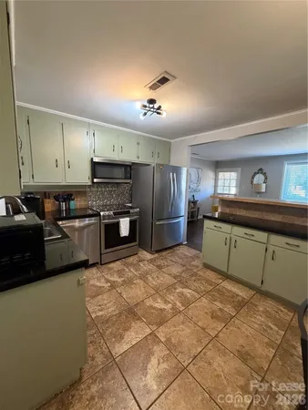 a kitchen with stainless steel appliances kitchen island granite countertop a sink cabinets and microwave