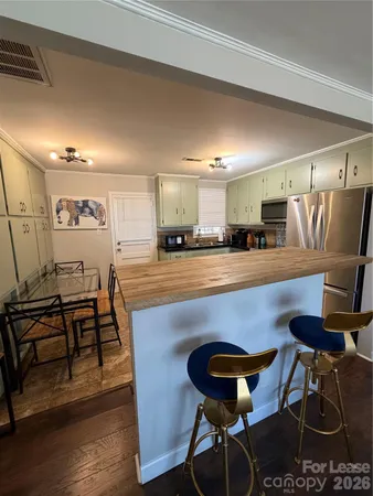 a kitchen with a dining table chairs and wooden floor