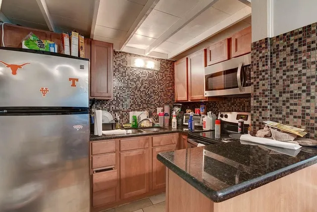 a kitchen with stainless steel appliances granite countertop a sink stove and microwave