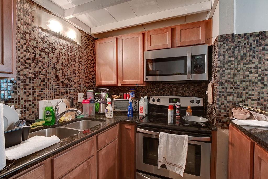 1000 West 26th Street, Unit 216 Austin, TX 78705 - Photo 12 of 16 a kitchen with stainless steel appliances a stove a sink a microwave and cabinets
