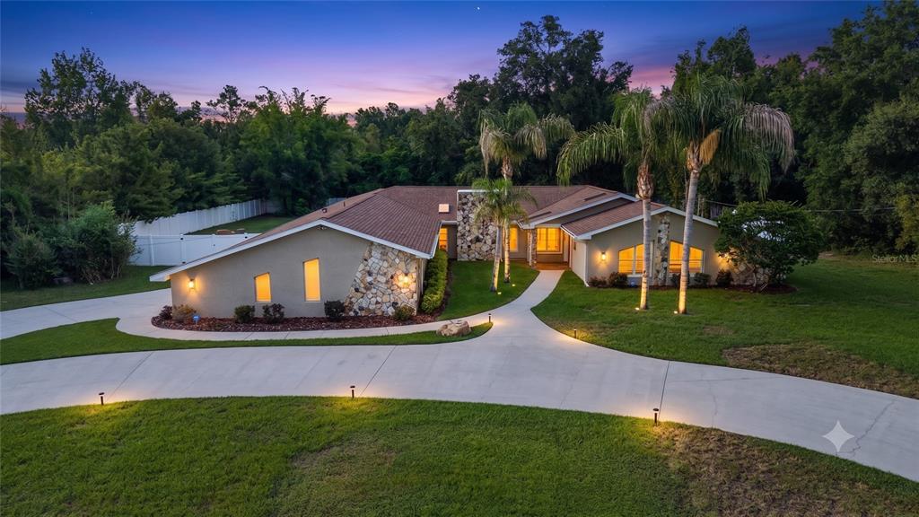 7487 River Country Drive Weeki Wachee, FL 34607 - Photo 1 of 53 a view of a big house with a big yard and potted plants