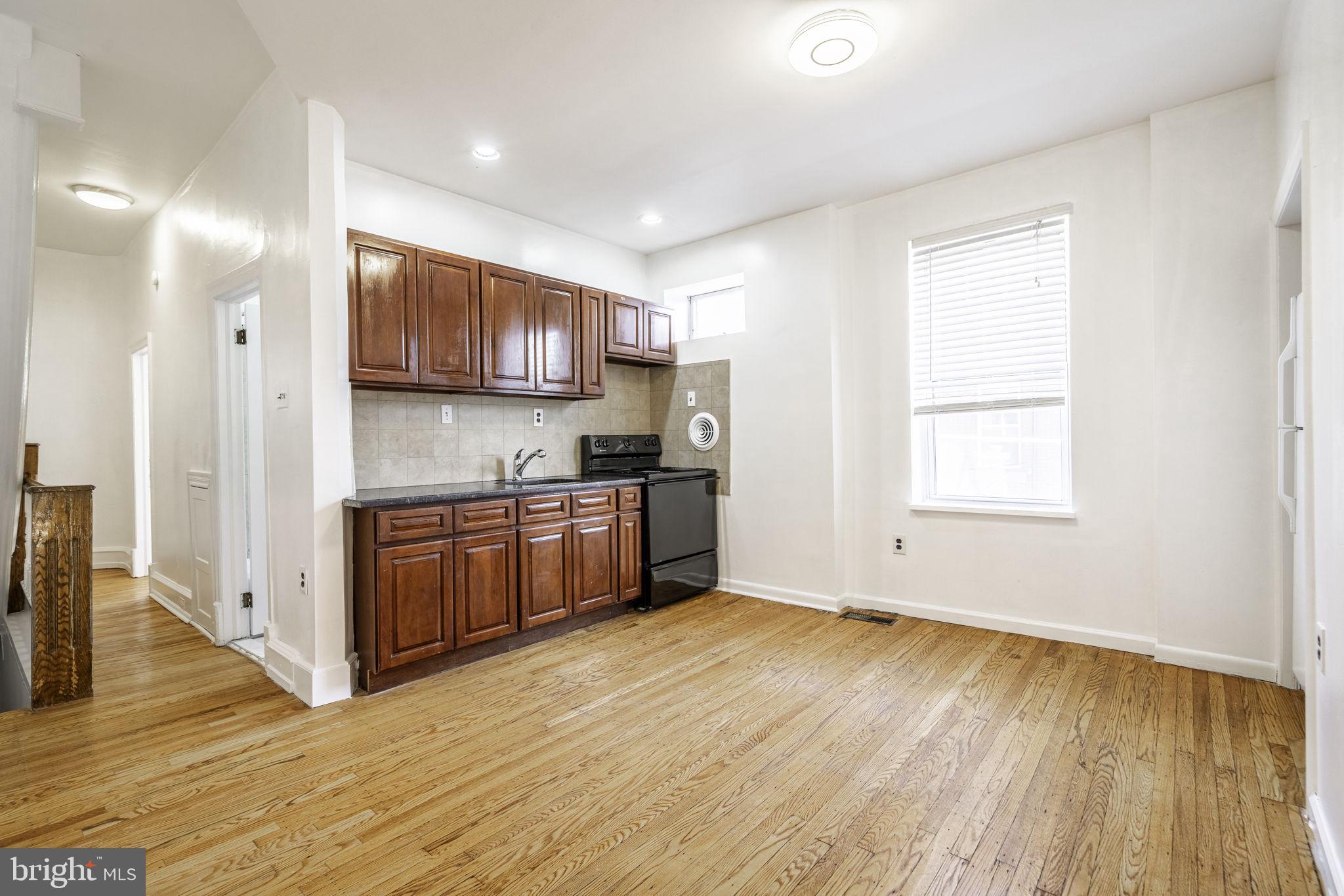 1314 West Ritner Street Philadelphia, PA 19148 - Photo 12 of 19 a kitchen with kitchen island granite countertop wooden floors stainless steel appliances a sink and a window