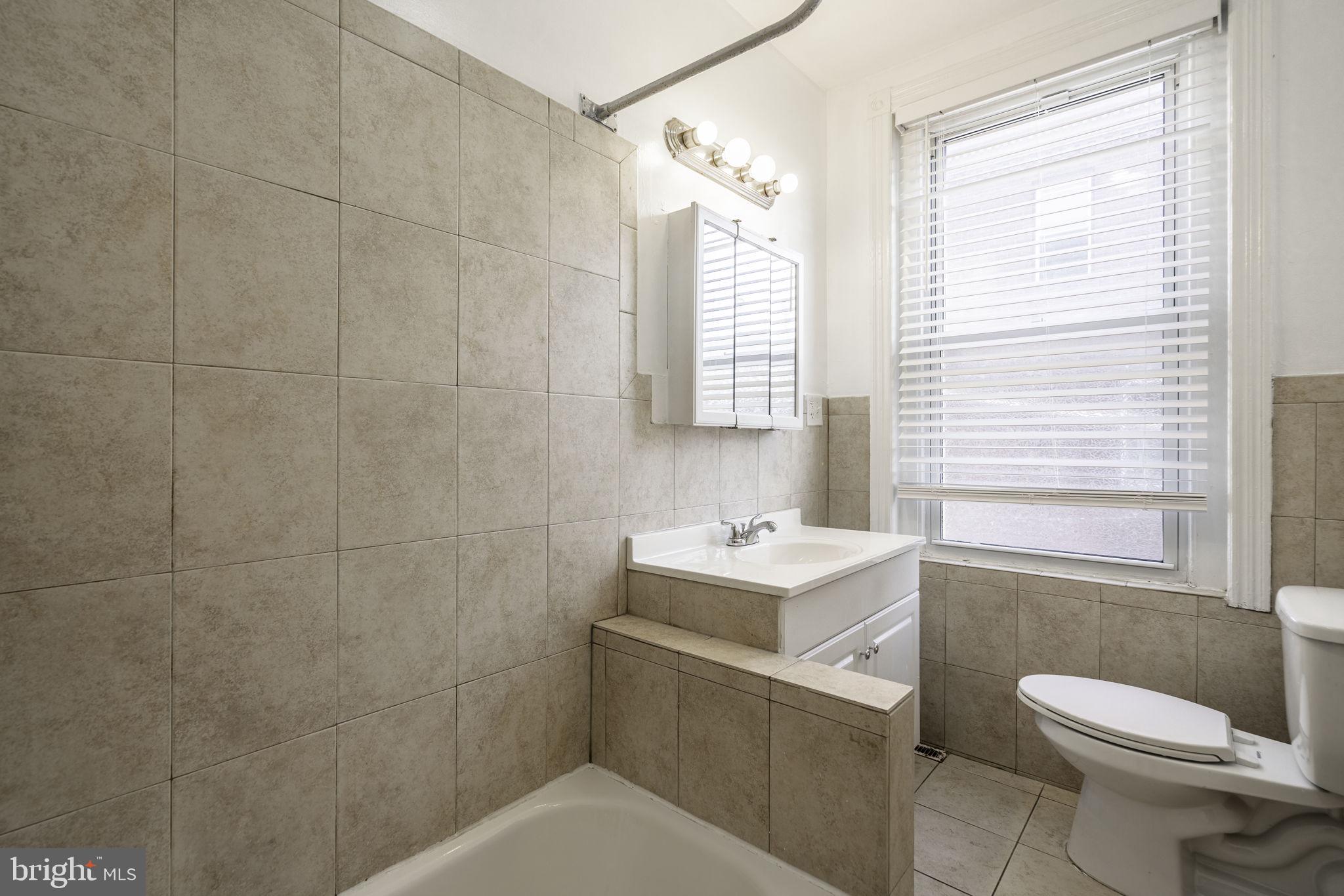 1314 West Ritner Street Philadelphia, PA 19148 - Photo 9 of 19 a bathroom with a toilet sink vanity and mirror