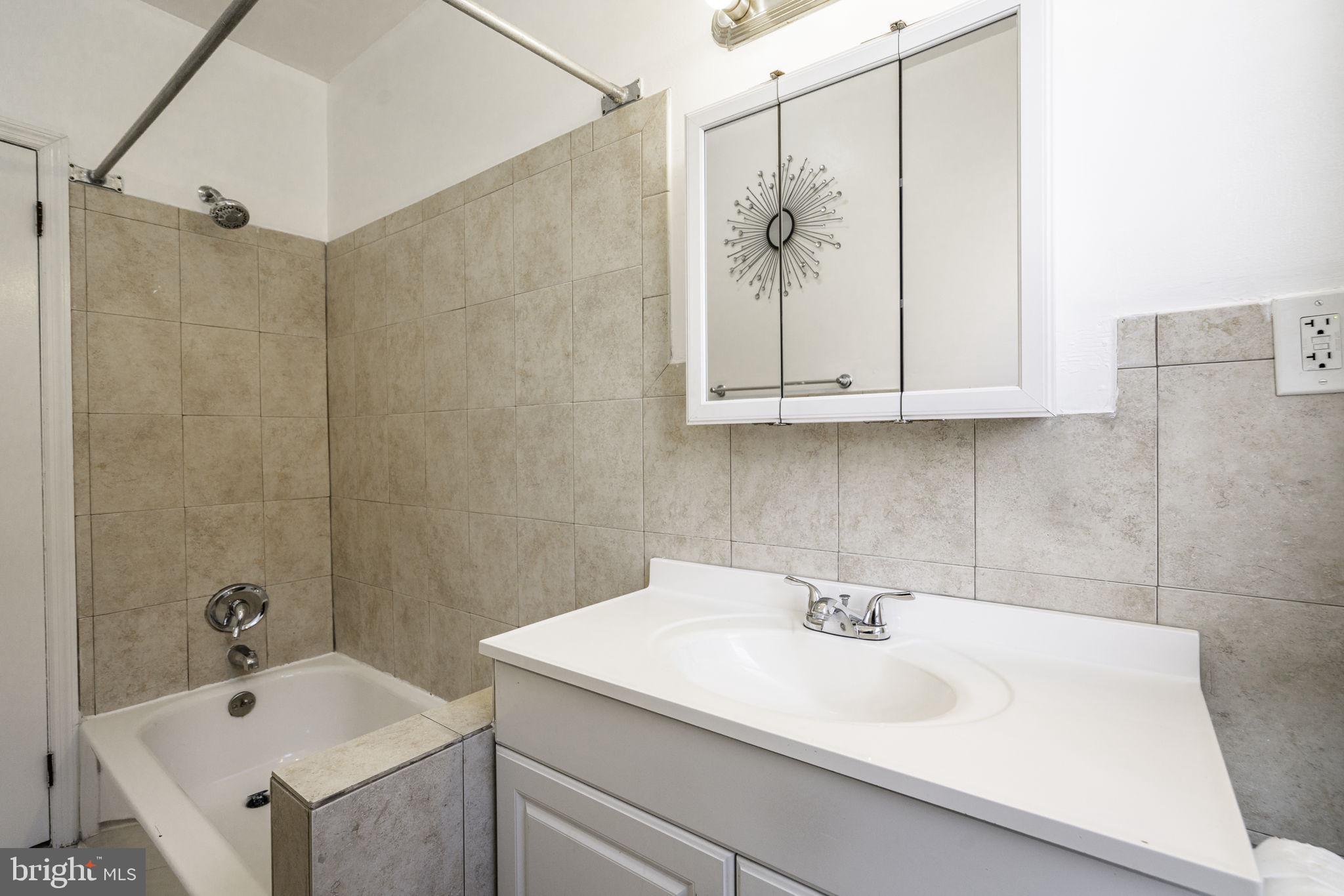 1314 West Ritner Street Philadelphia, PA 19148 - Photo 10 of 19 a bathroom with a sink a mirror and a shower