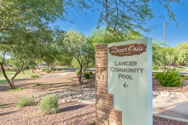 a view of a house with a yard and table and chairs under an umbrella