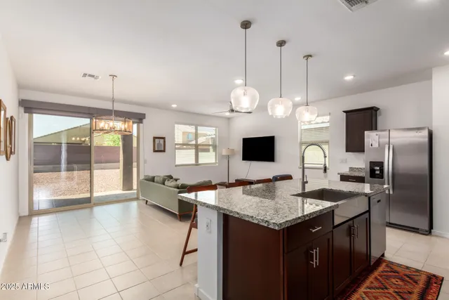 a kitchen with granite countertop a sink a counter top space appliances and cabinets
