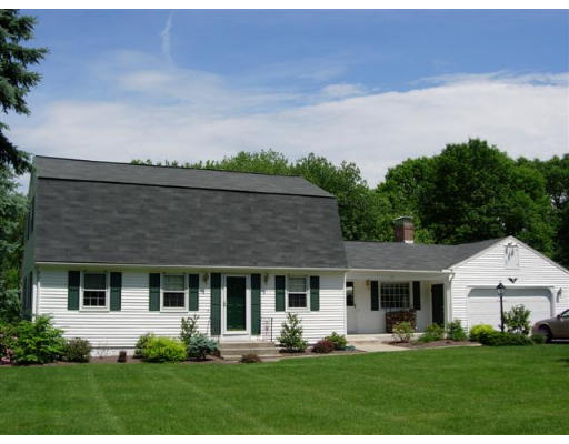 a front view of a house with a yard and trees