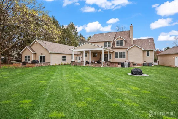 a view of a white house with a yard and large tree