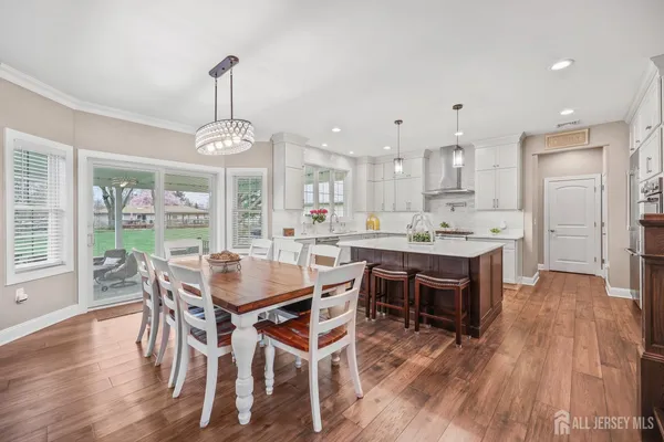 a view of a dining room and livingroom with furniture wooden floor a chandelier