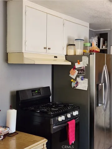 a kitchen with stainless steel appliances granite countertop a stove a refrigerator and a microwave