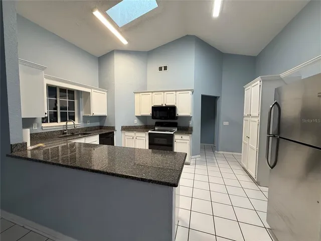 a large kitchen with a large counter top stainless steel appliances and cabinets