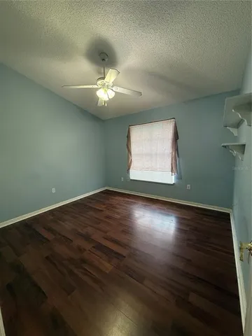 an empty room with wooden floor and window