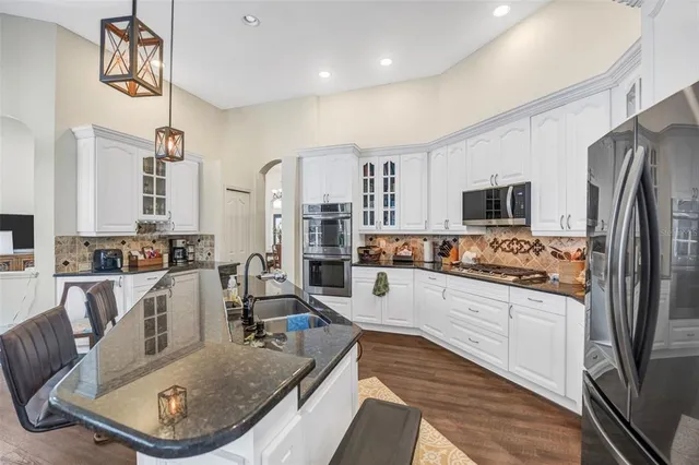 a living room with couches a fireplace and a large mirror with potted plants