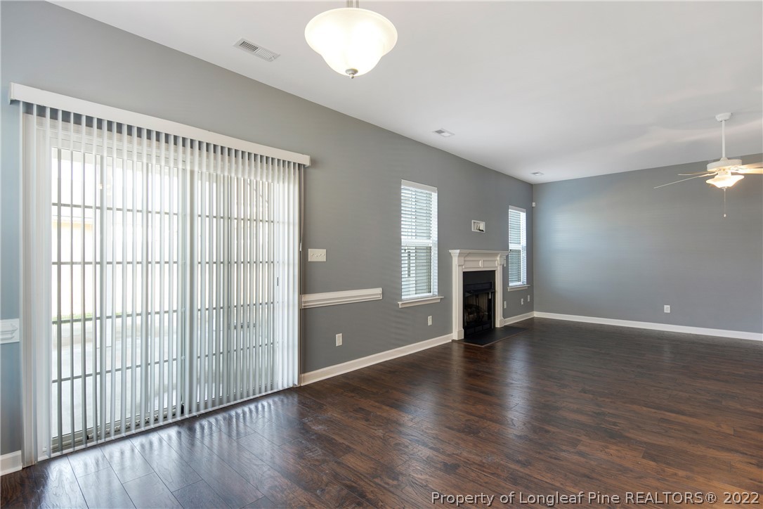 826 Harry Truman Road Fayetteville, NC 28311 - Photo 13 of 48 an empty room with wooden floor and fireplace