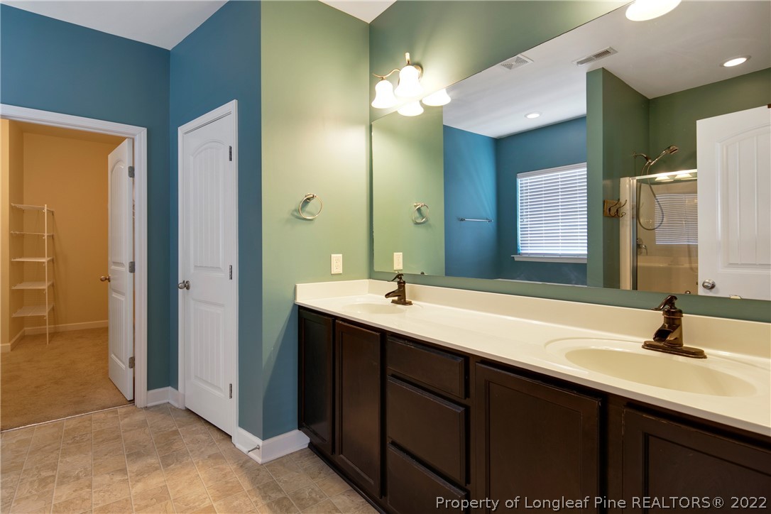 826 Harry Truman Road Fayetteville, NC 28311 - Photo 25 of 48 a bathroom with a double vanity sink and a mirror