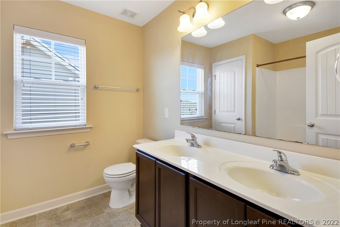 826 Harry Truman Road Fayetteville, NC 28311 - Photo 41 of 48 a bathroom with a sink a toilet and a mirror