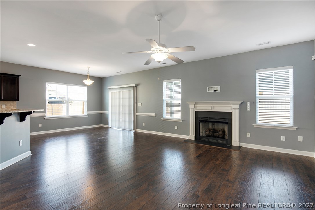 826 Harry Truman Road Fayetteville, NC 28311 - Photo 6 of 48 an empty room with wooden floor fireplace and windows