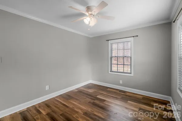 an empty room with a window and a ceiling fan