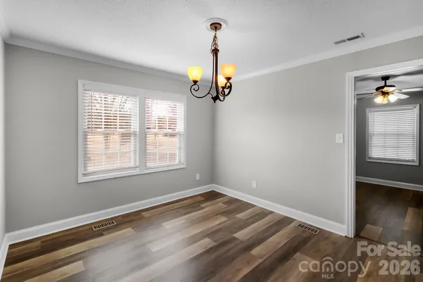 a view of empty room with wooden floor and window