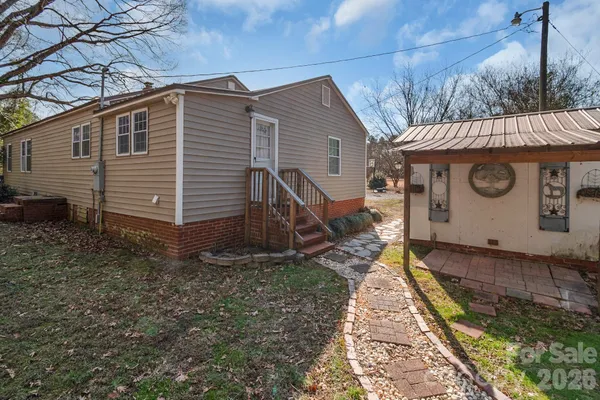 a view of a house with yard and wooden fence