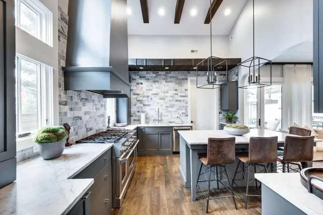 a kitchen with stainless steel appliances a sink a stove and a wooden floors