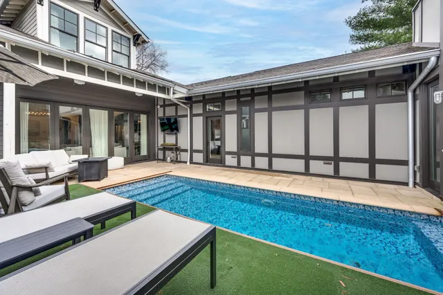 a view of a dining room with furniture a kitchen and chandelier