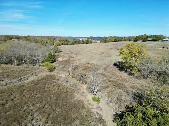 a view of a dry yard with wooden fence