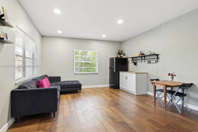 a living room with furniture and a wooden floor
