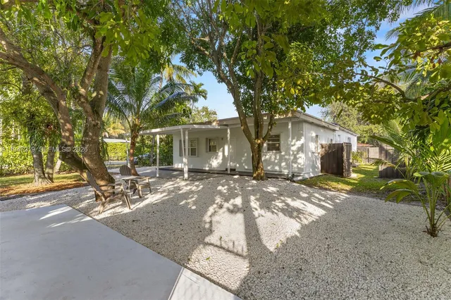 a view of a house with backyard and a tree
