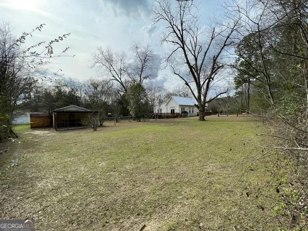 a view of a house with backyard and trees