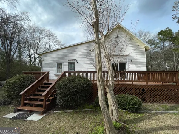 a view of a house with a yard and wooden fence