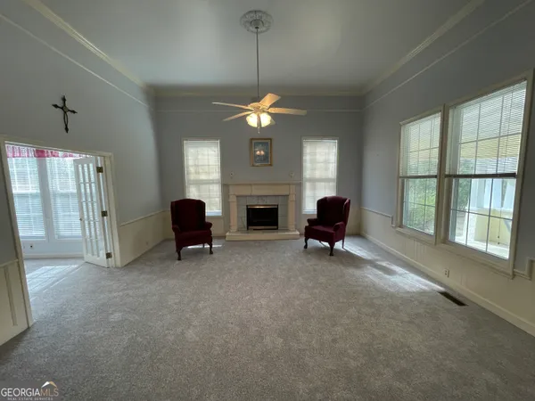 an empty room with fan and windows