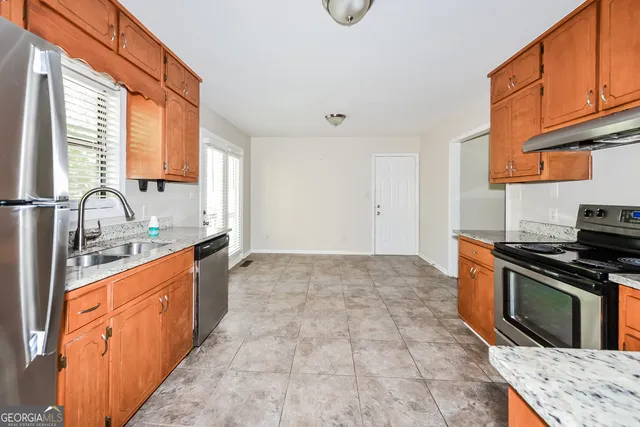 a large kitchen with stainless steel appliances granite countertop a stove a sink and a microwave