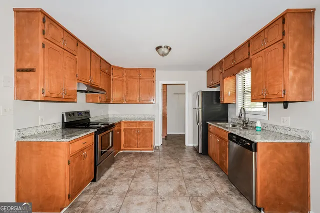a kitchen with stainless steel appliances granite countertop a stove sink and cabinets