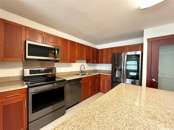 a kitchen with stainless steel appliances kitchen island granite countertop a stove top oven and sink