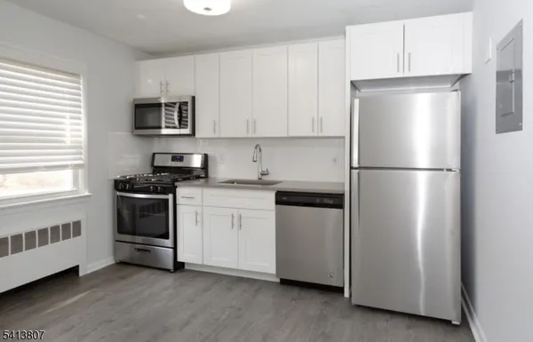 a kitchen with a refrigerator stove and white cabinets
