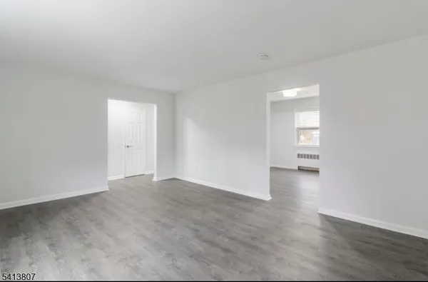 a view of an empty room and wooden floor