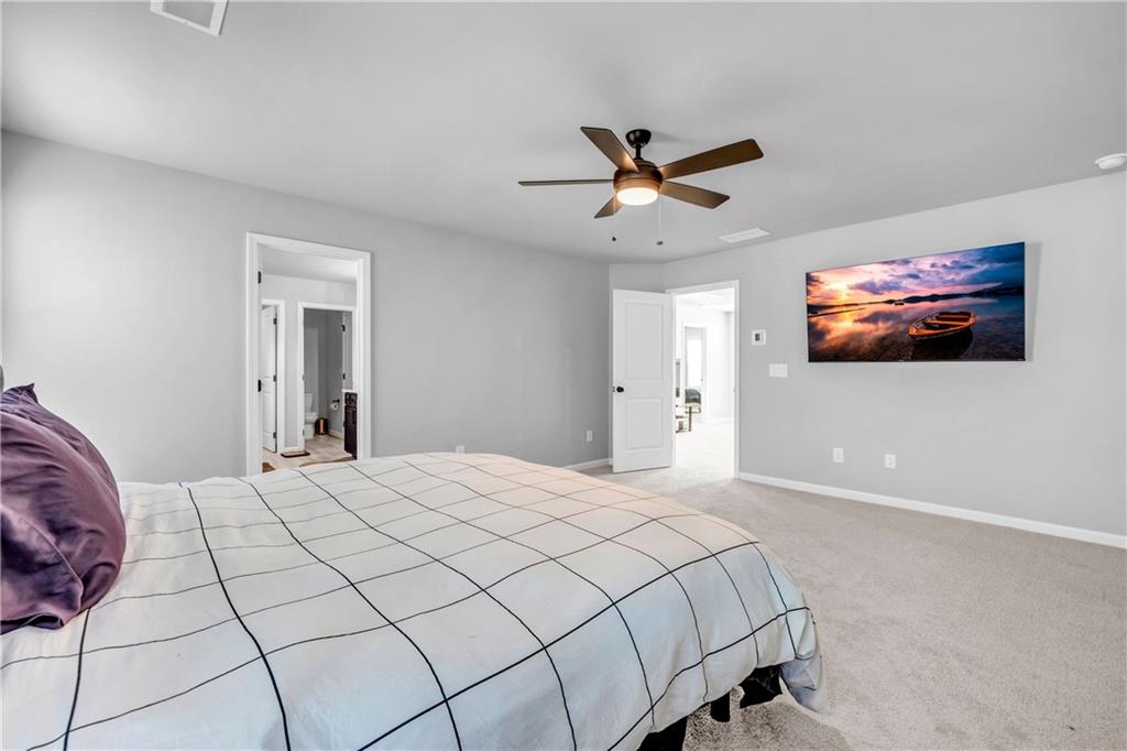 6095 Marigold Way Atlanta, GA 30349 - Photo 11 of 17 a bedroom with a large bed and a chandelier