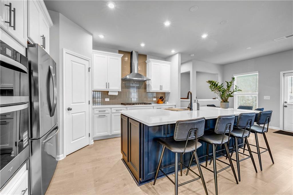 6095 Marigold Way Atlanta, GA 30349 - Photo 3 of 17 a kitchen with stainless steel appliances a table chairs refrigerator and cabinets