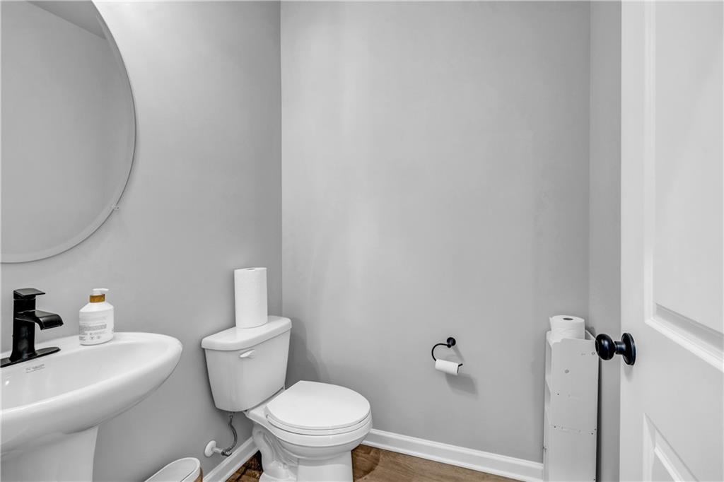 6095 Marigold Way Atlanta, GA 30349 - Photo 10 of 17 a white toilet sitting next to a bathroom sink